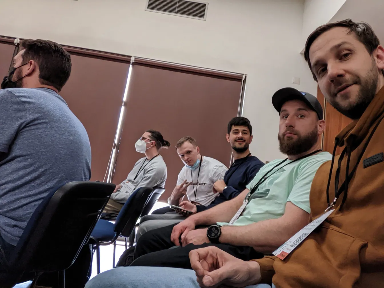 Group of conference attendees seated in a row, some wearing Speednet lanyards.