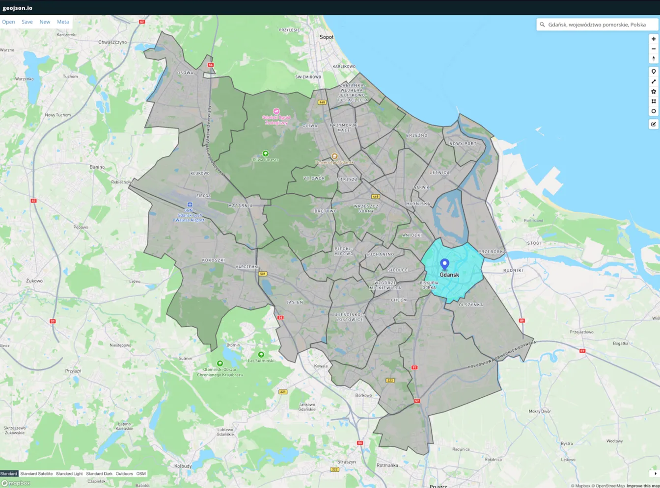 Zrzut ekranu platformy geojson.io z zaimportowaną mapą Gdańska, zaznaczonym obszarem miasta i pinezką lokalizacji.