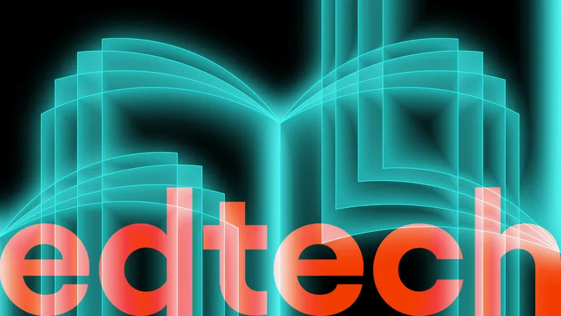 Ilustracja świecącej otwartej książki, a pod nią napis "edtech" pomarańczowymi literami.