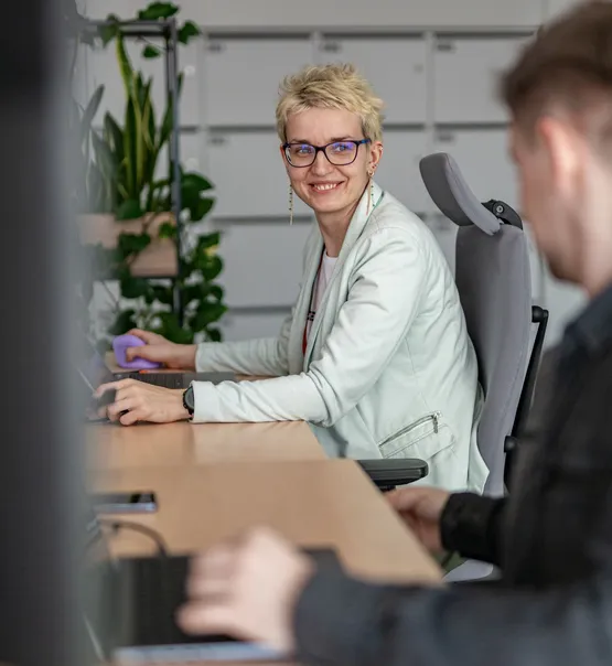 A Speednet team member smiling at a desk.