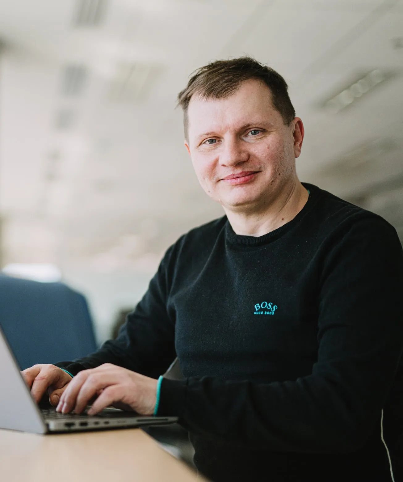 A Speednet engineer working on a laptop at an office desk.