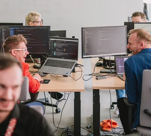Zespół Speednet przy biurkach, na monitorach kod