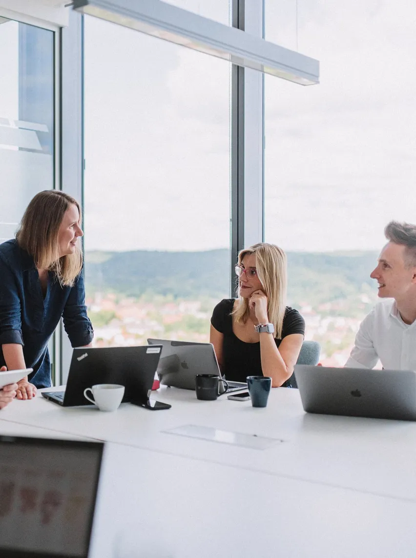 Speednet team members in a meeting room with a view over the city.