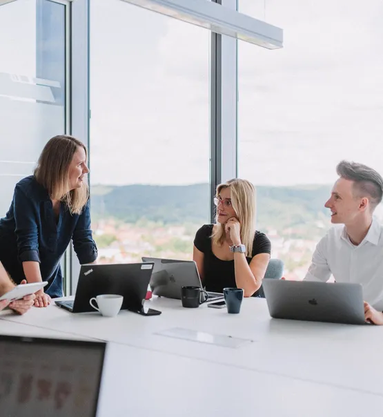 Speednet team members in a meeting room with a view over the city.