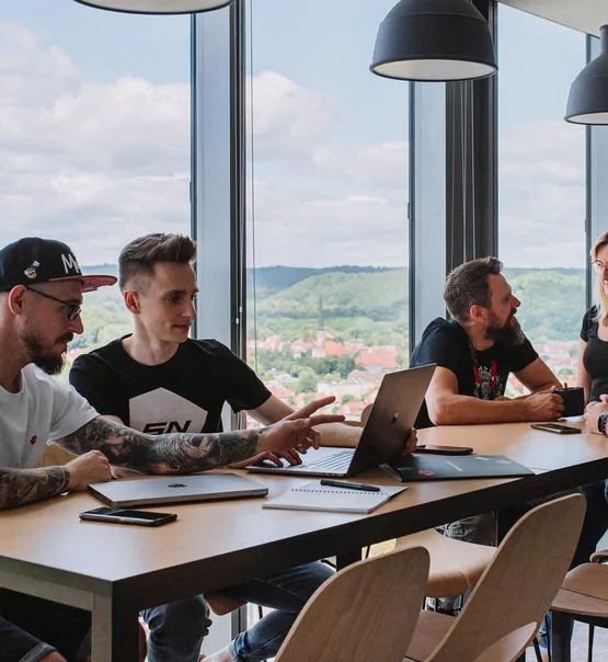 Zespół Speednet omawia pracę przy stole pod oknem.